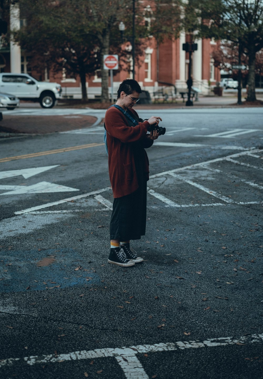 Ein Mann steht mitten auf einer Straße und hält eine Kamera in der Hand