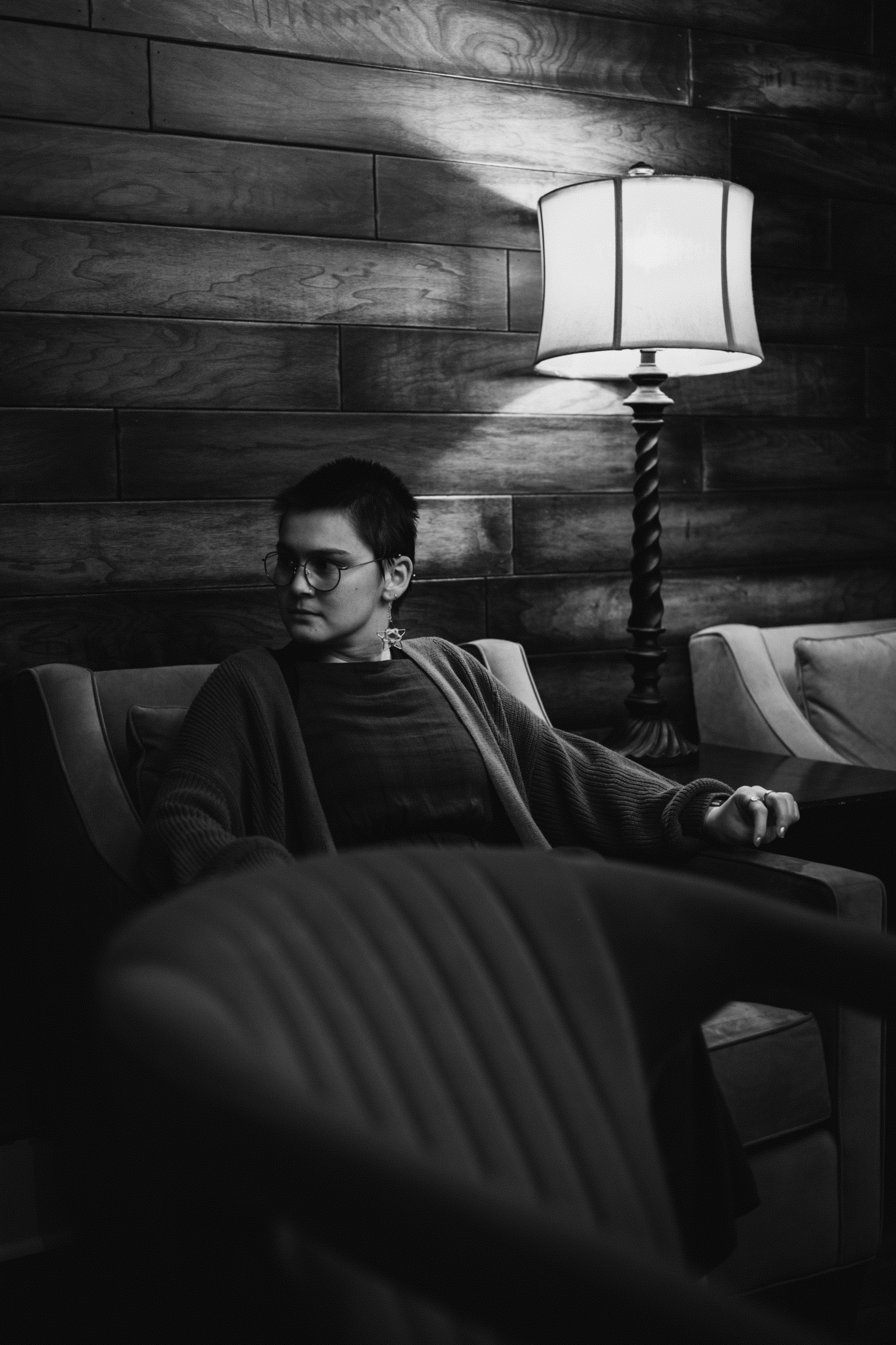 A man sitting in a chair next to a lamp