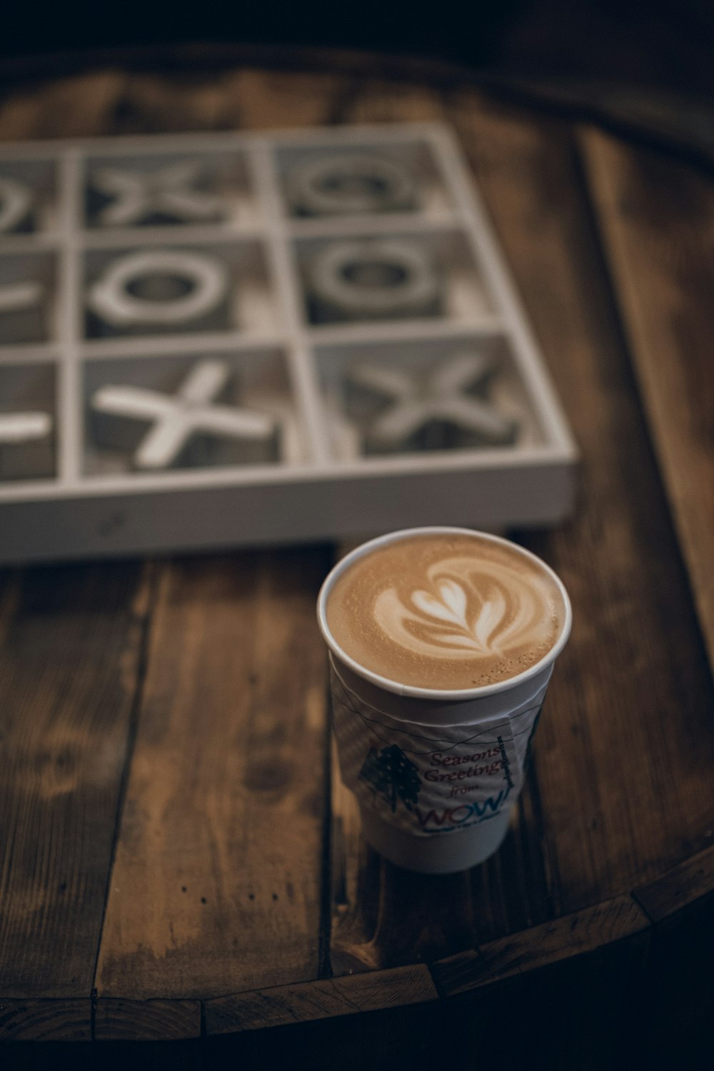 a cup of coffee sitting on top of a wooden table