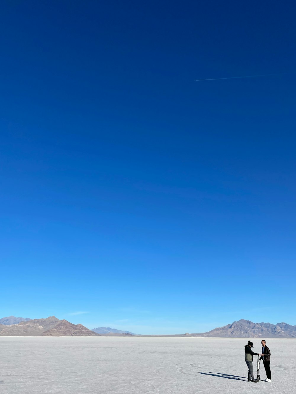 a couple of people standing in the middle of a desert