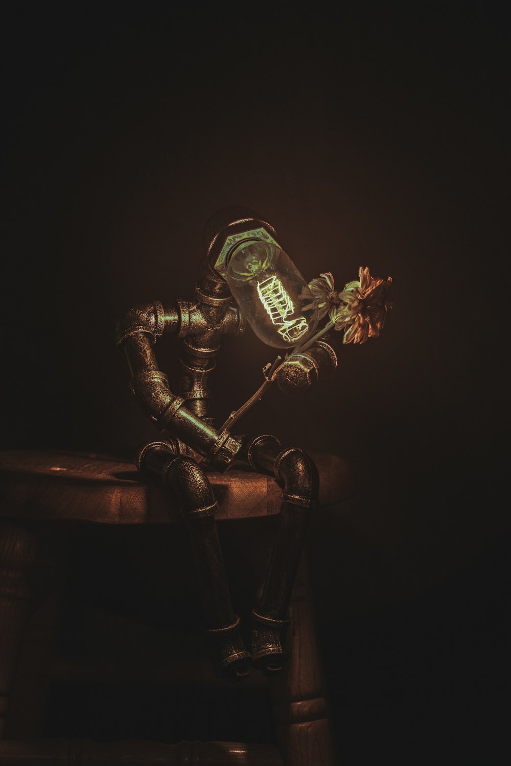 a steampunked man sitting on a chair holding a flower