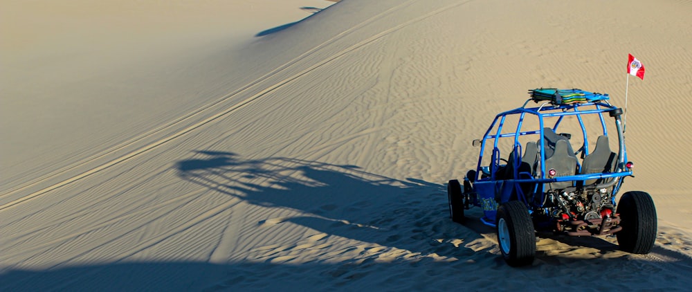 Un buggy sur une dune de sable avec un drapeau canadien au sommet