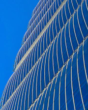 A sleek modern skyscraper in Dubai shining under a clear blue sky.