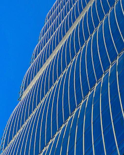 A sleek modern skyscraper in Dubai shining under a clear blue sky.