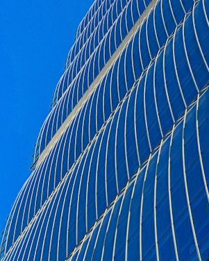 A sleek modern skyscraper silhouette against a clear blue sky, symbolizing strategic urban development.