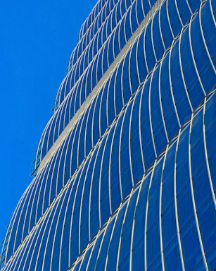 A sleek modern skyscraper gleaming under a clear blue sky.
