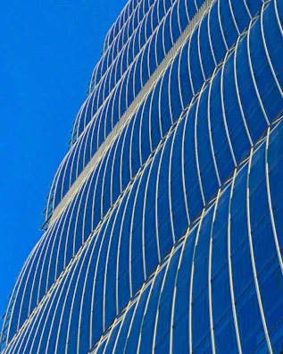 A luxurious commercial skyscraper with reflective glass facade under a clear sky.
