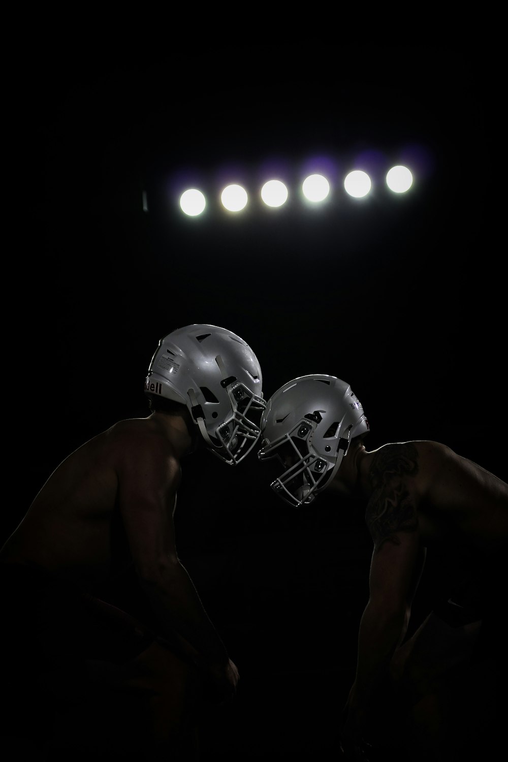 two football players are facing each other in the dark
