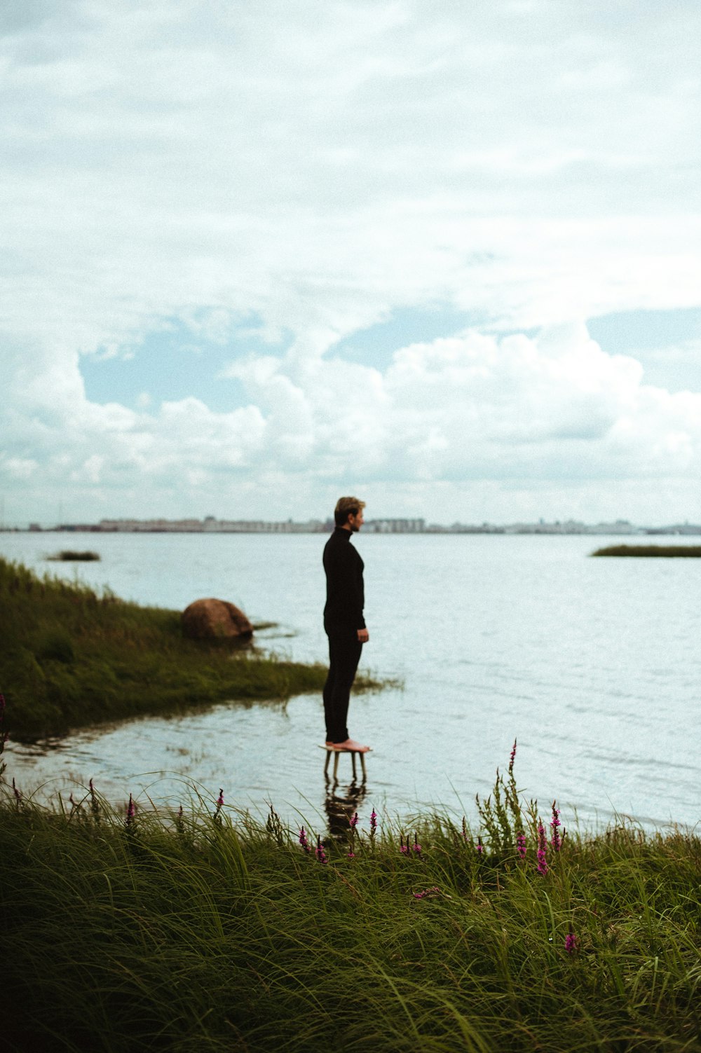 a man standing next to a body of water