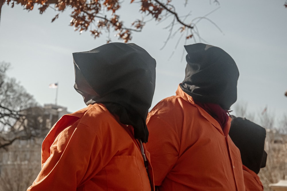 a couple of people in orange jackets standing next to each other