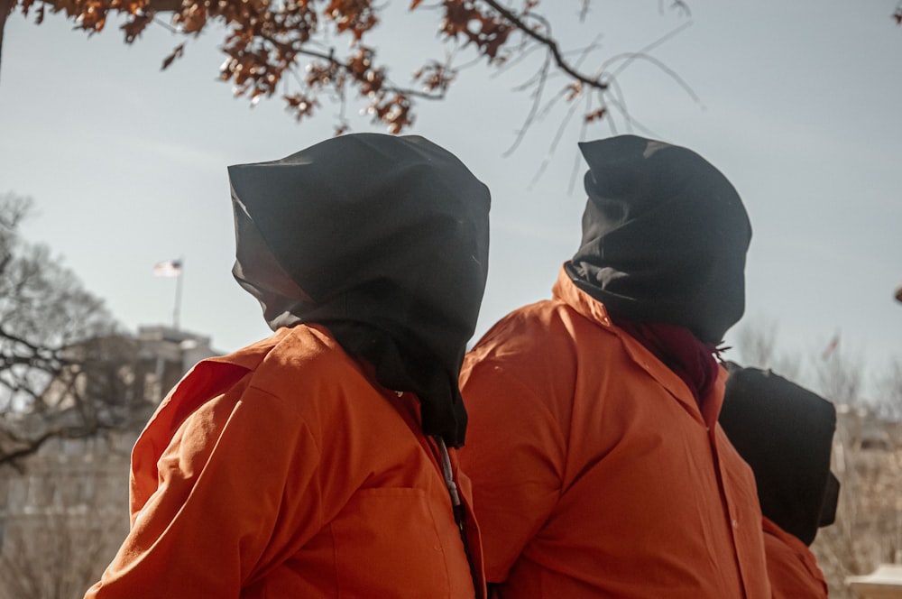 Un couple de personnes en veste orange debout l’une à côté de l’autre