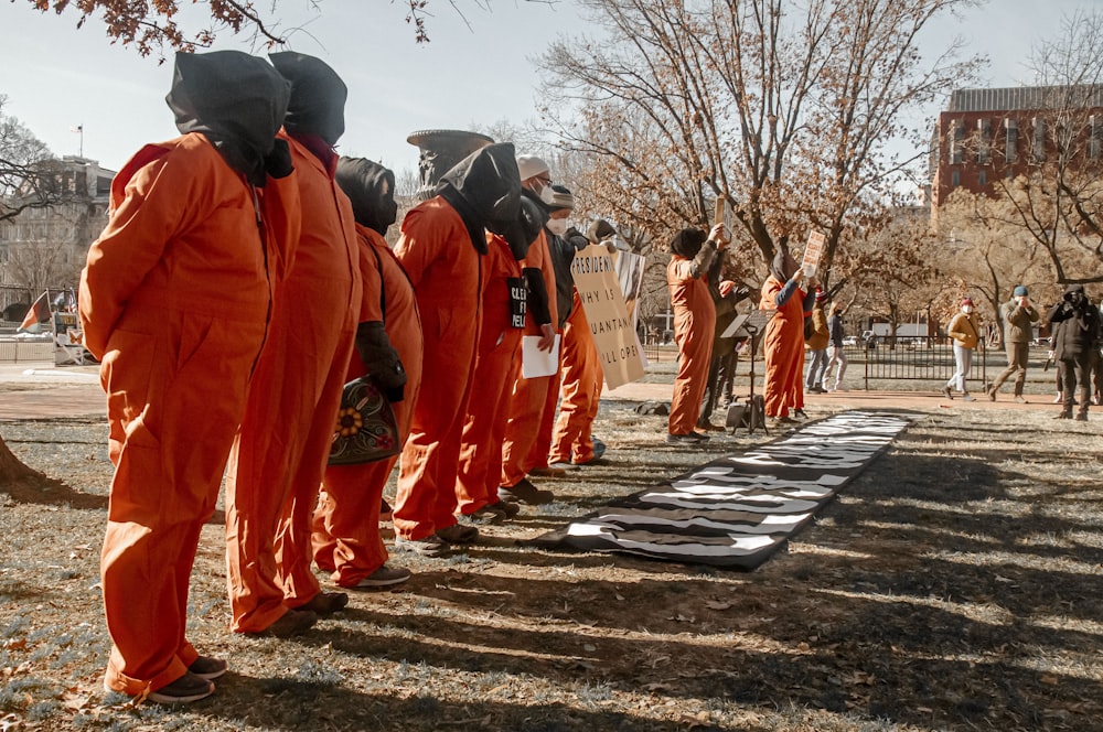 a group of people in orange jumpsuits standing in a line