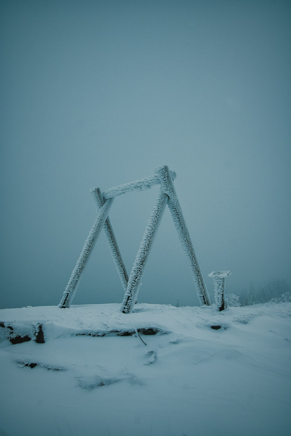 a wooden structure sitting in the middle of a snow covered field