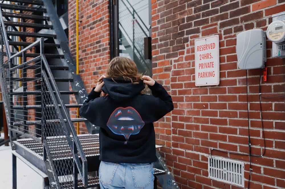 a person standing in front of a brick building