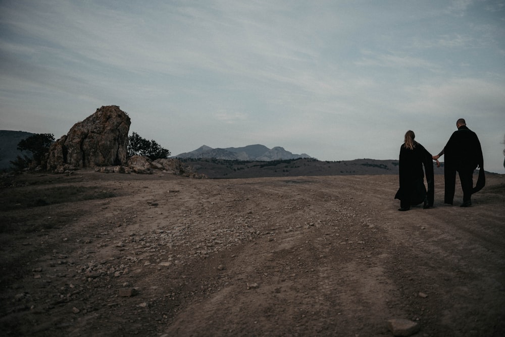 a man and a woman are walking in the desert