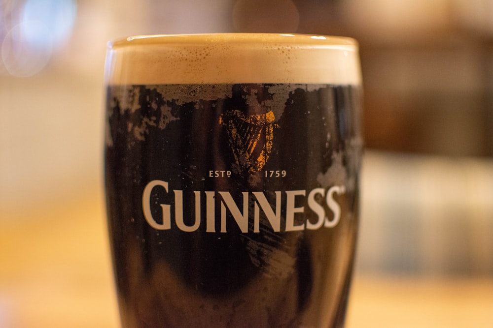 a glass of beer sitting on top of a table