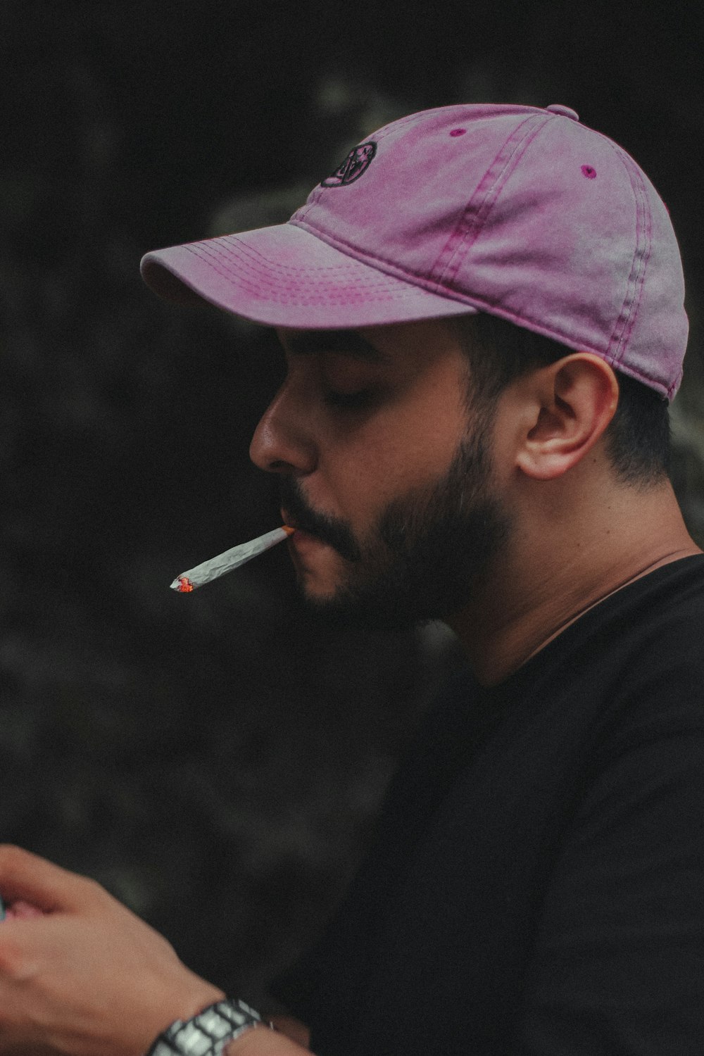 a man in a pink hat smoking a cigarette