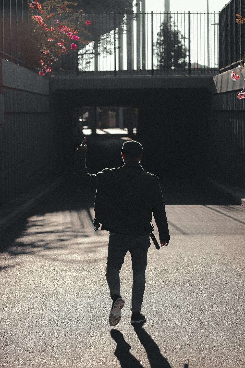 a man walking down a street holding a skateboard