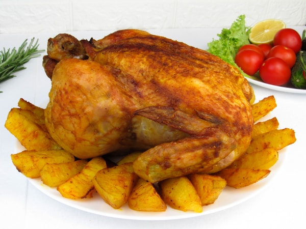 A roasted turkey and potatoes on a white plate