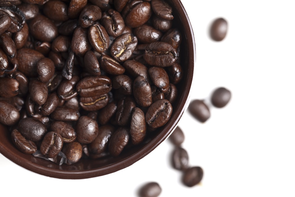 a bowl filled with coffee beans on top of a table