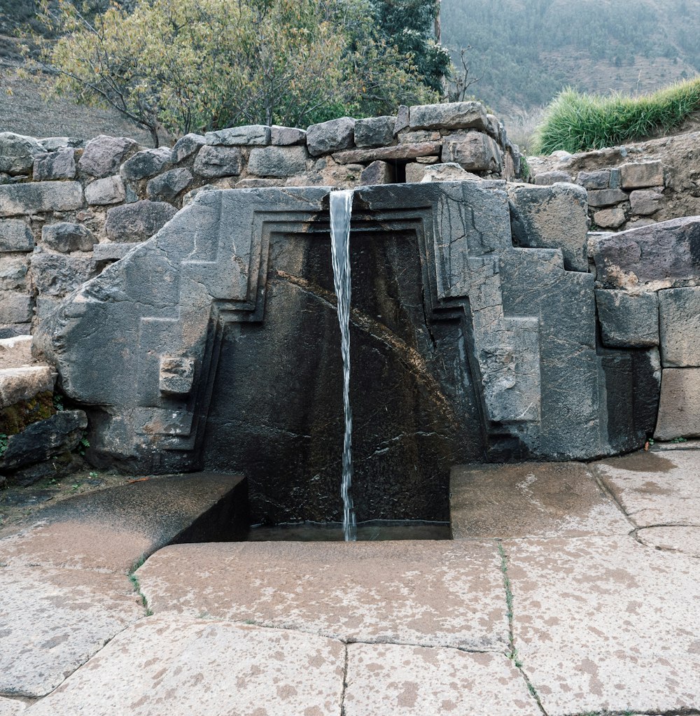 uma grande estrutura de pedra com uma cachoeira saindo dela