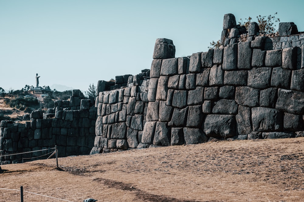 a stone wall with a cross on top of it