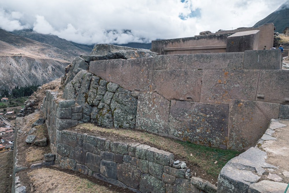 a stone bench sitting on the side of a mountain