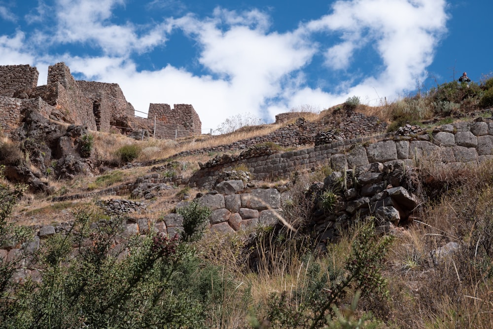 Un muro de piedra en una colina con un fondo de cielo