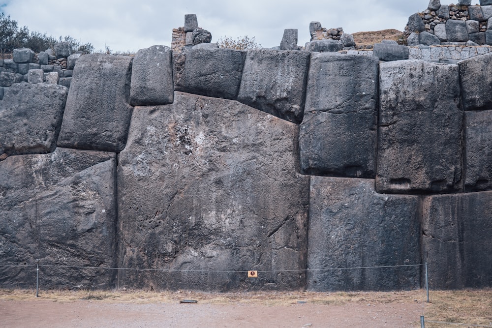 a large rock formation with a fence in front of it