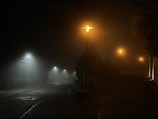 A foggy street at night, setting a mysterious, suspenseful mood.