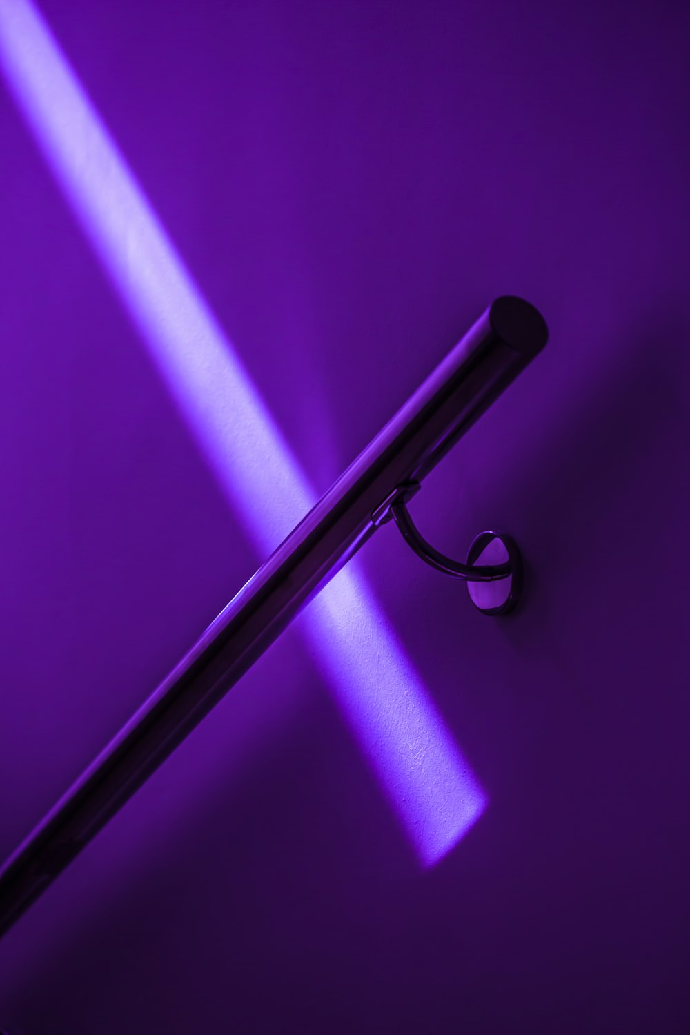 紫色の背景に黒いハンドルを持つ紫色の傘