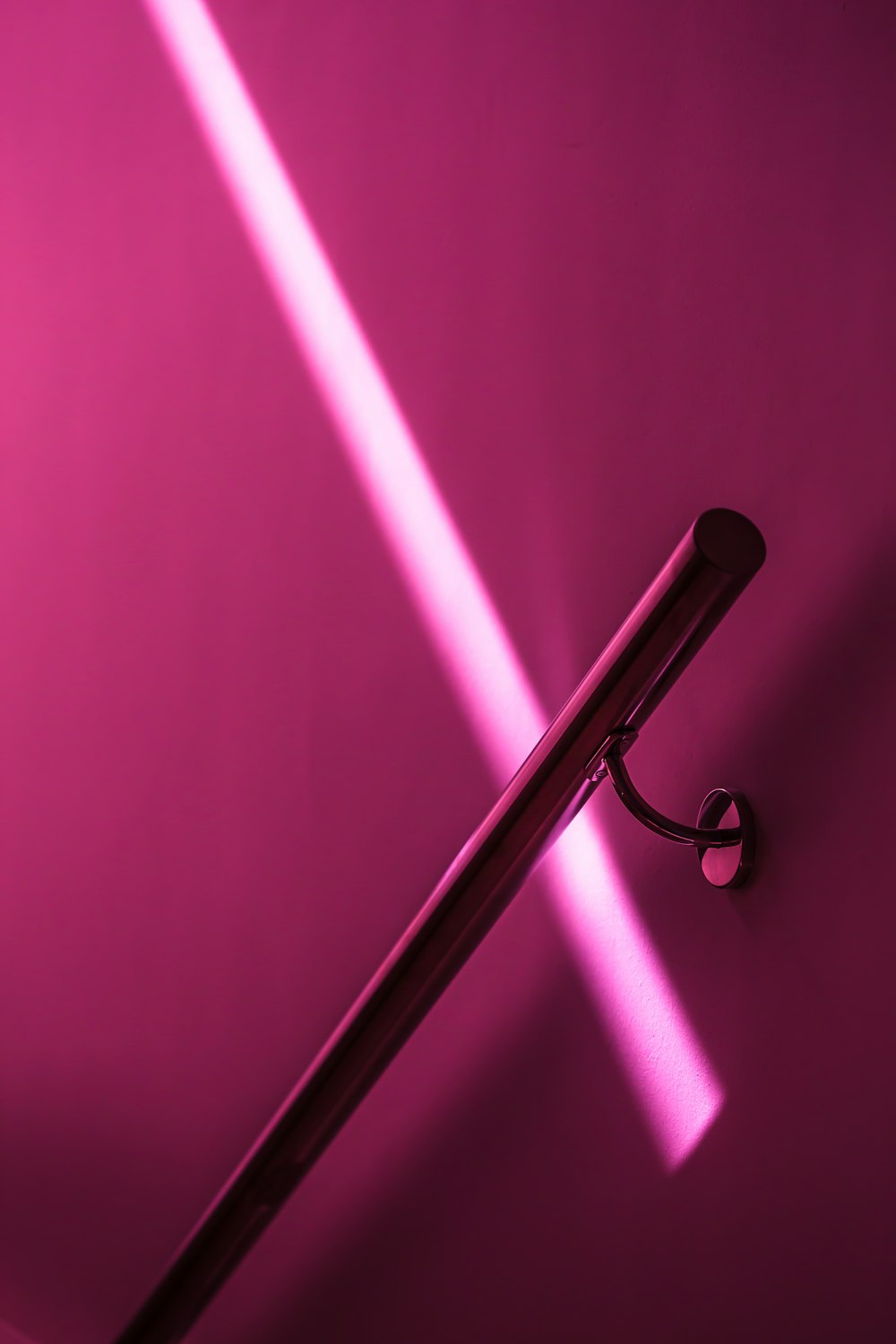 a pink wall with a metal handle on it