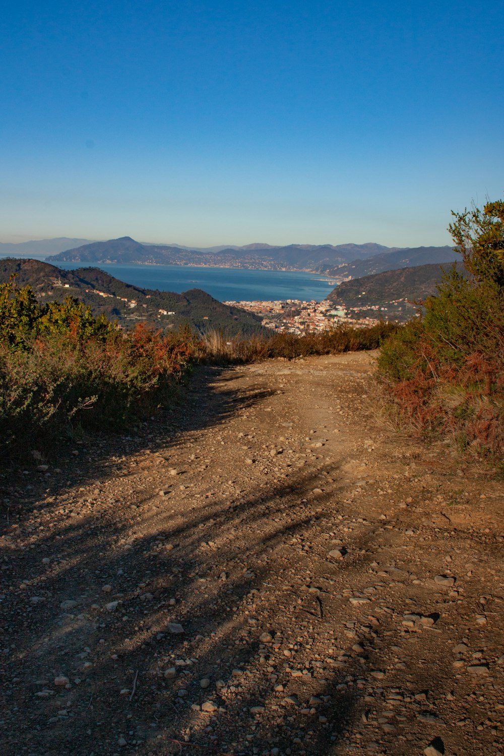 a dirt road with a view of the ocean