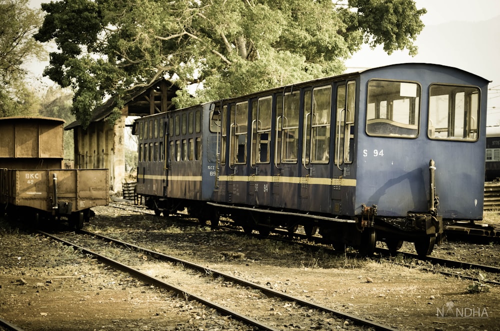 a blue train car sitting on top of train tracks