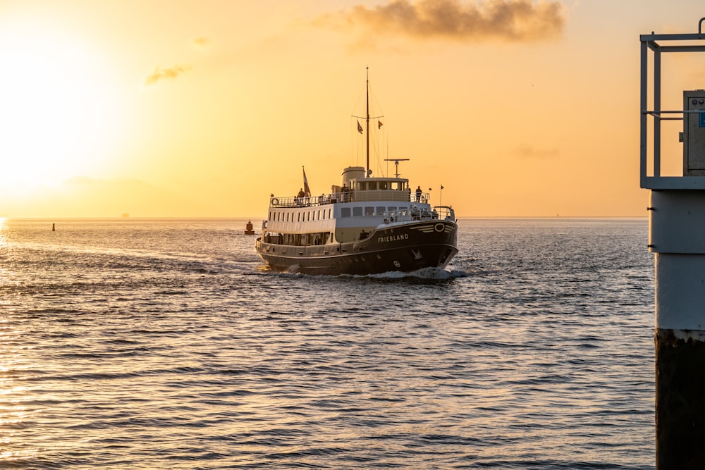 a large boat in the ocean at sunset