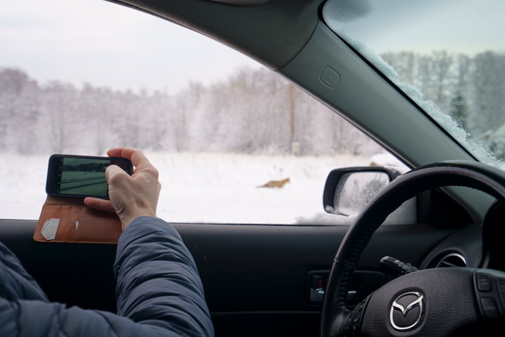 a person sitting in a car using a cell phone