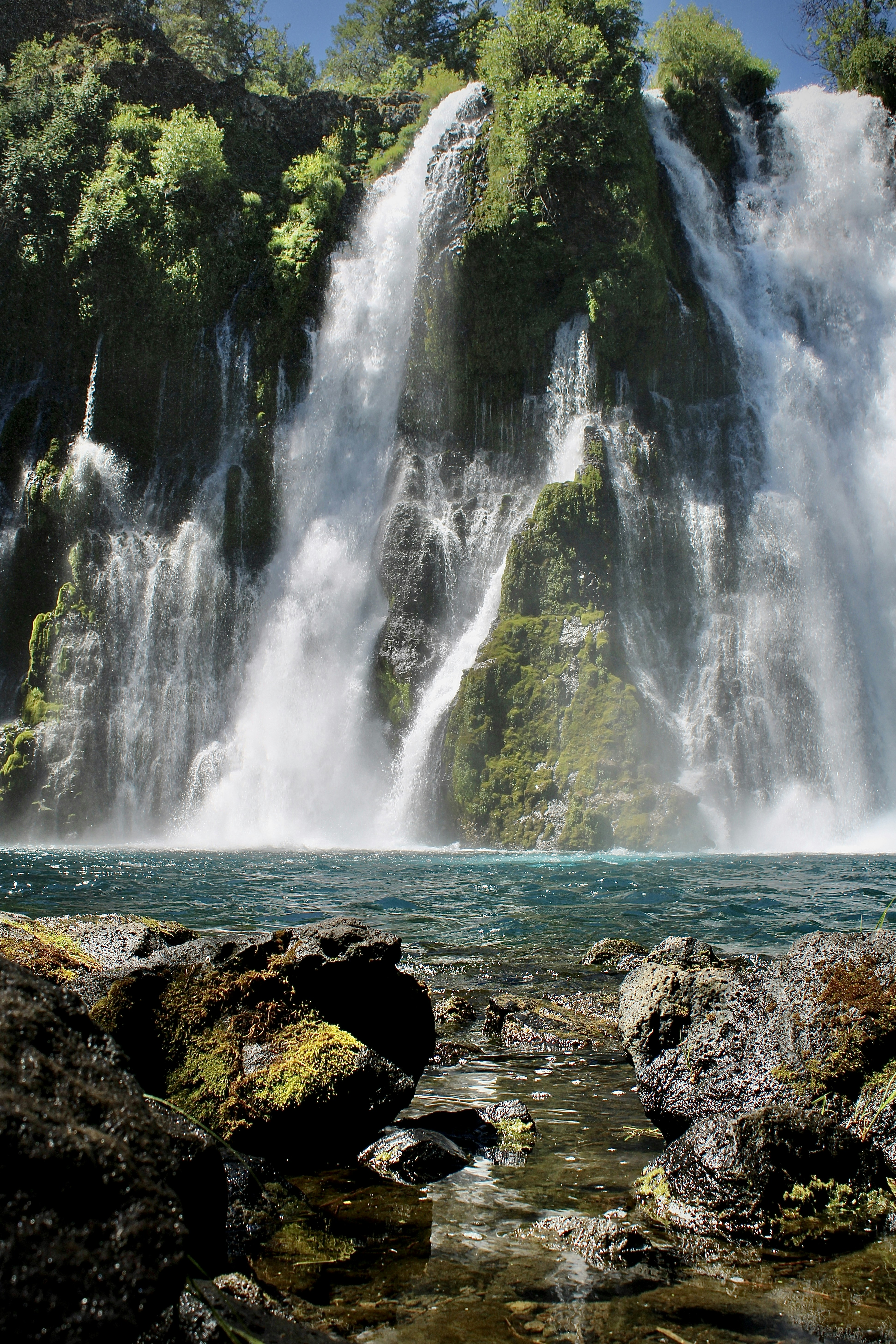 a large waterfall in the middle of a body of water
