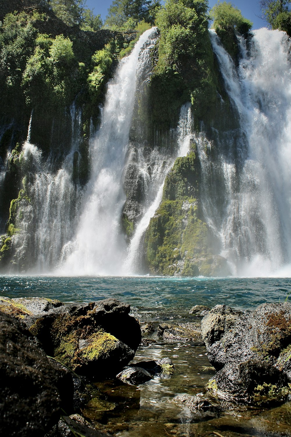 a large waterfall in the middle of a body of water