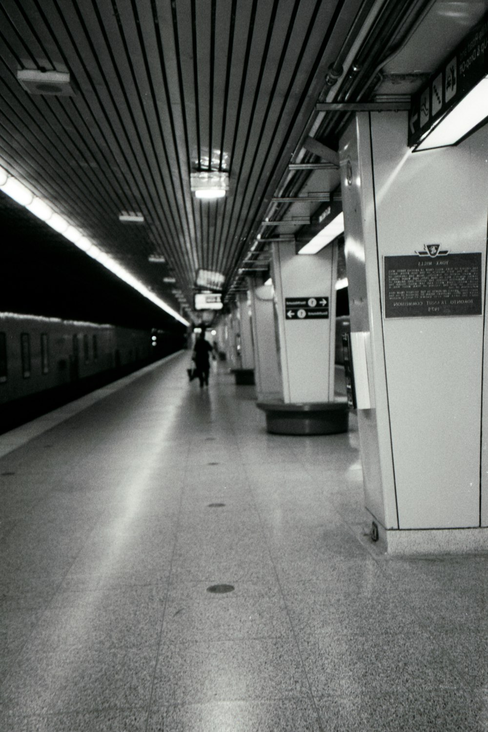 a black and white photo of a subway station