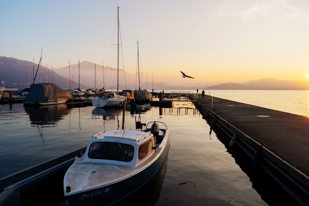 a boat is docked at a pier at sunset