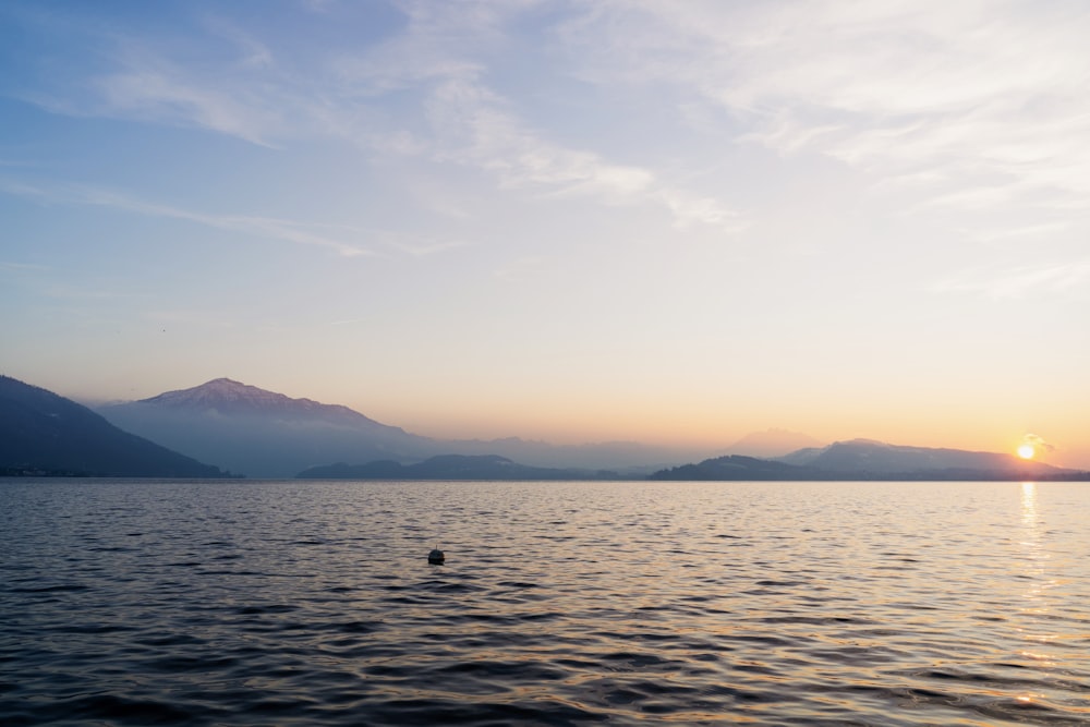 a body of water with mountains in the background