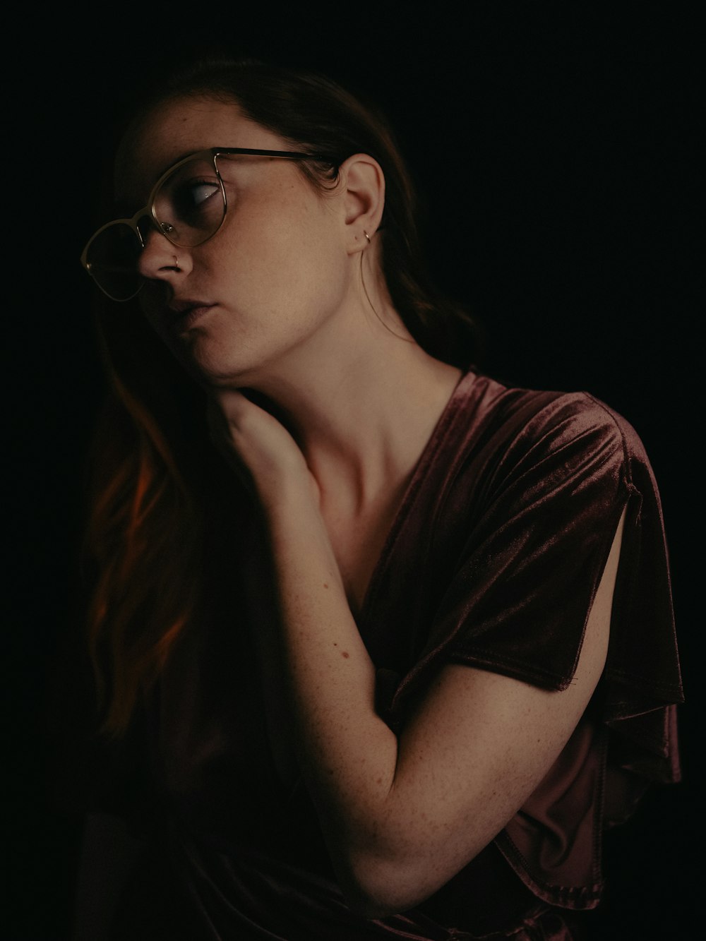 a woman in a brown shirt and glasses