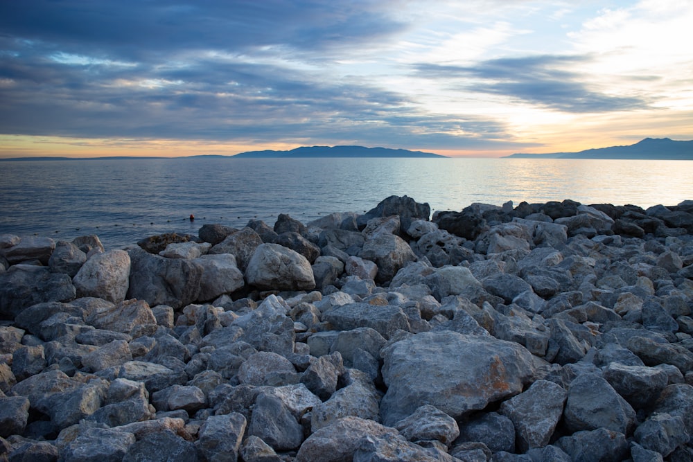 a bunch of rocks that are by the water