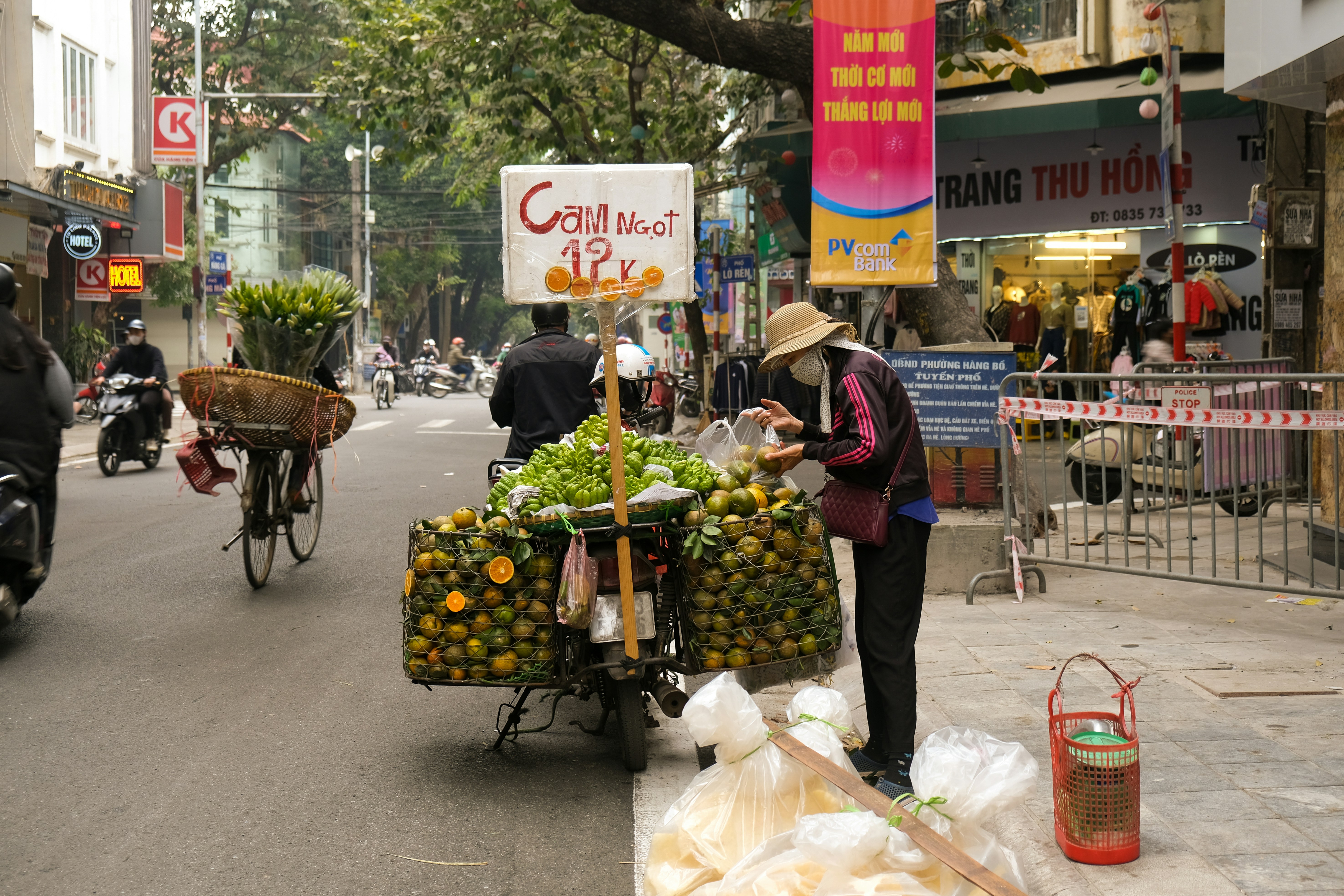 a person pushing a cart full of fruit down a street
