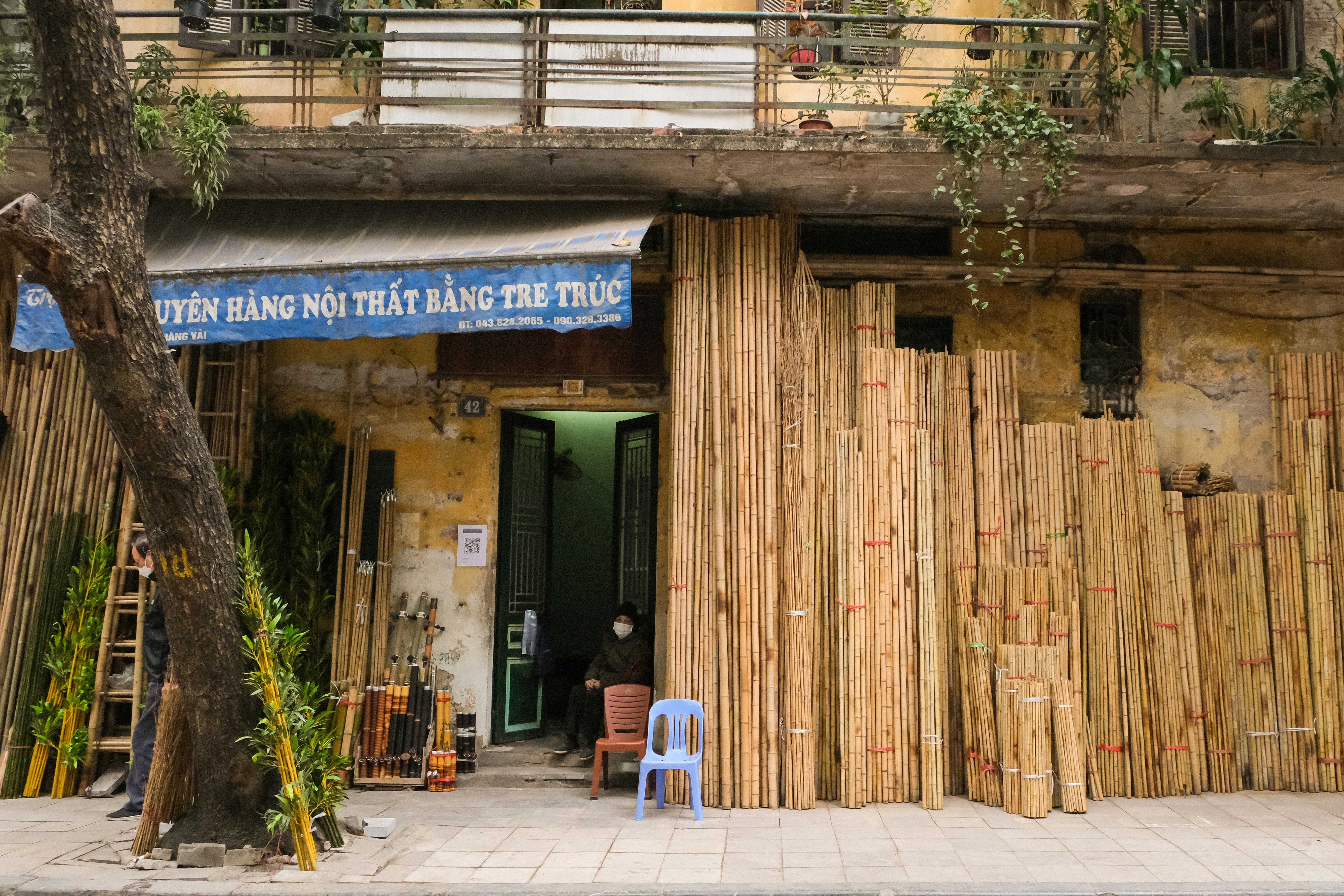 Ein Gebäude, das einen Haufen Bambus an der Außenseite hat