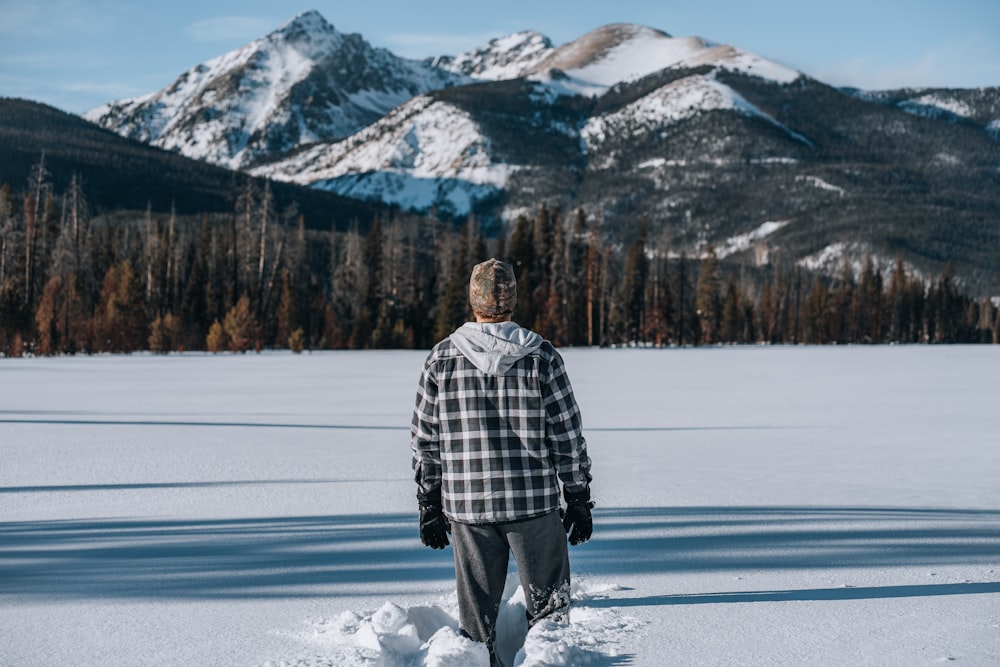 a man walking across a snow covered field