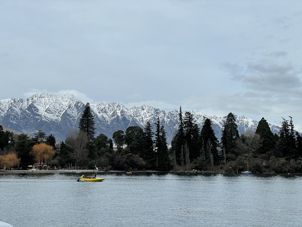 a body of water with snow covered mountains in the background