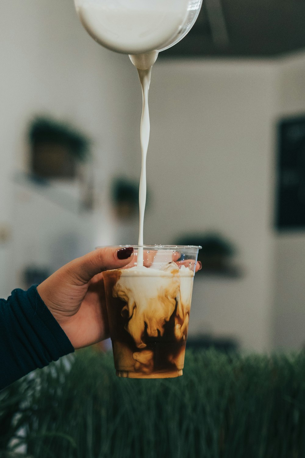 a person is pouring milk into a cup