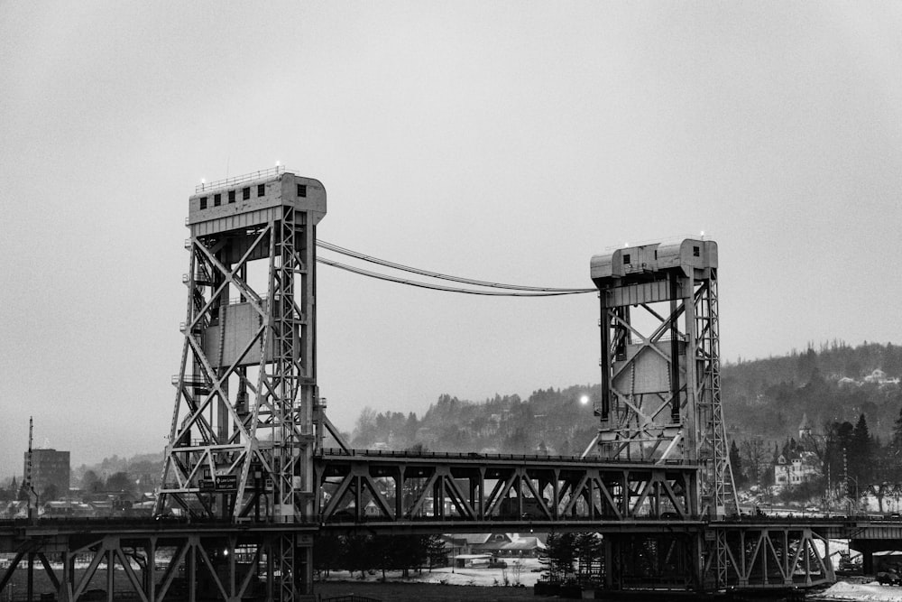 a black and white photo of a train crossing a bridge