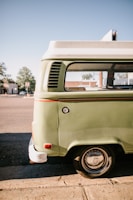 Yellow van parked in a sunny urban street with green accents.